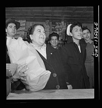 New York, New York. Italian-American customers in a grocery store on Mulberry Street. This woman said she wished her son in Trinidad could see the picture of her. Sourced from the Library of Congress.