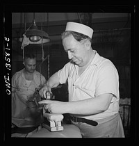 New York, New York. Garment worker in the N.M. dress shop, which is now making blouses for the Women's Army Auxiliary Corps (WAAC). He is a member of local 89 of the International Ladies Garment Workers' Union. Sourced from the Library of Congress.
