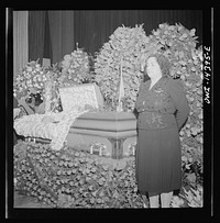 New York, New York. Woman wearing a one-star pin showing that she has a son in the United States Armed Services, guarding the coffin containing the body of murdered Carlo Tresca as mourners pass by to pay their respects. Sourced from the Library of Congress.