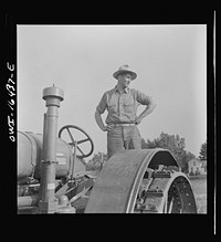 [Untitled photo, possibly related to: Jackson, Michigan. Soldier, who was granted a furlough to help with the harvesting on this farm, watching threshing]. Sourced from the Library of Congress.