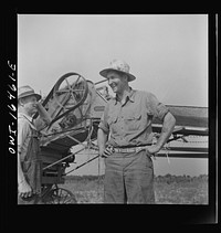 [Untitled photo, possibly related to: Jackson, Michigan. Soldier who was granted a furlough to help with the harvesting on this farm, and farmer watching the threshing]. Sourced from the Library of Congress.