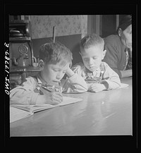 Trampas, New Mexico. The Lopez children doing their homework on the kitchen table. Sourced from the Library of Congress.