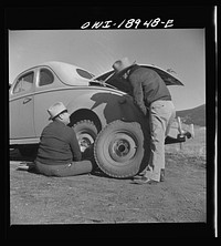 Moreno Valley, Colfax County, New Mexico. George Turner changing a tire. Sourced from the Library of Congress.