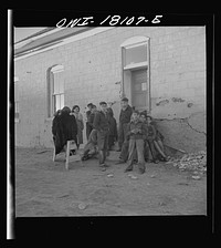 Questa, New Mexico. Natives listening to the evening news release from broadcasting station PSA, operated from the parish house by means of loudspeakers by Father Smith, priest to the parish of Questa. Sourced from the Library of Congress.