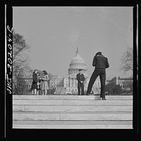 Washington, D.C. Sailor taking pictures on the steps of the National Gallery of Art on a Sunday afternoon. The Capitol is in the background. Sourced from the Library of Congress.