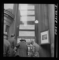 Baltimore, Maryland. Reading news bulletins and looking at the news pictures outside the Baltimore News building. Sourced from the Library of Congress.