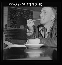 Pearlington, Mississippi. James Hall, truck driver, stopping for a cup of coffee and working on his log. Sourced from the Library of Congress.