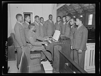 Camp Lejeune, New River, North Carolina. Private First Class Walker Manly, organist, rehearsing with members of the 51st Composite Battalion for a camp chapel service. Sourced from the Library of Congress.
