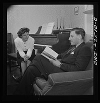 [Untitled photo, possibly related to: Swedish-American foreman at the SKF roller bearing plant reads to his Italian-American wife at home. Philadelphia, Pennsylvania]. Sourced from the Library of Congress.