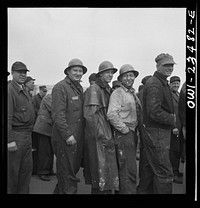 Bethlehem-Fairfield shipyards, Baltimore, Maryland. Lining up before a time clock at the changing of the shifts. Sourced from the Library of Congress.