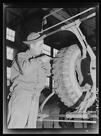 Holabird ordnance depot, Baltimore, Maryland. In the recapping shop, after visual inspection, the tire is put in a tire spreader for thorough inside and outside inspection. Here a soldier is using a probe to remove a nail from the tire. Sourced from the Library of Congress.