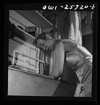 Arlington, Virginia. A girl washing her hair in a laundry tub at Arlington Farms, a residence for women who work in the government for the duration of the war. Sourced from the Library of Congress.