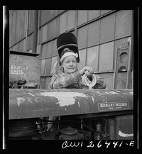 Bethlehem-Fairfield shipyards, Baltimore, Maryland. Girl welder resting on a welding machine. Sourced from the Library of Congress.