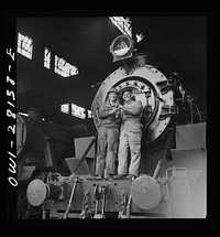 American and British engineers taking time out for a smoke. They are standing on an American engine somewhere in Iran. Sourced from the Library of Congress.