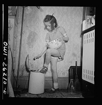 Buffalo, New York. Mary Grimm, eight, doing the housework.  Her mother, a twenty-six year old widow, is a crane operator at Pratt and Letchworth. Sourced from the Library of Congress.