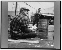 New York, New York. New England fisherman checking baskets of fish as they are lifted from his ship. Sourced from the Library of Congress.