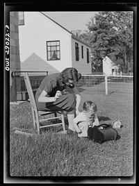 [Untitled photo, possibly related to: A mother sewing a button on her child's overalls. Silver Spring, Maryland]. Sourced from the Library of Congress.