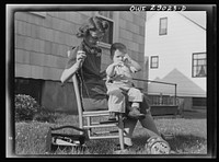 [Untitled photo, possibly related to: A mother sewing a button on her child's overalls. Silver Spring, Maryland]. Sourced from the Library of Congress.
