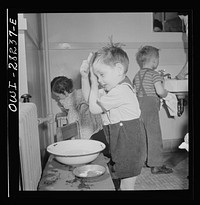 Buffalo, New York. Lakeview nursery school for children of working mothers, operated by the Board of Education at a tuition fee of three dollars weekly. Children themselves washing and combing their hair. Sourced from the Library of Congress.