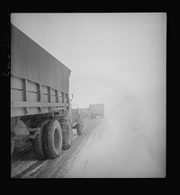 Somewhere in the Persian corridor. United States Army trucks carrying supplies for the aid of Russia. American truck convoy in one-way snowbound mountain pass must get by this disabled truck which is risky on a slippery climb. Sourced from the Library of Congress.