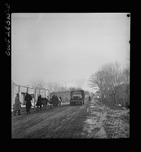 Somewhere in the Persian corridor. A United States Army truck convoy carrying supplies for the aid of Russia. The convoy passing through a Persian village. Sourced from the Library of Congress.