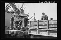 Ship to railroad car to truck--no time is lost moving supplies for Russia from a Liberty ship to a railroad car to a truck somewhere in the Middle East. Sourced from the Library of Congress.