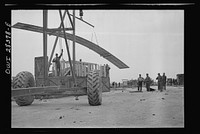 Mobile crane lifting the top from a crate containing a United States fighter plane awaiting assembly at the assembly, testing, and delivery point of American warplanes destined for Russia. Somewhere in Iran. Sourced from the Library of Congress.