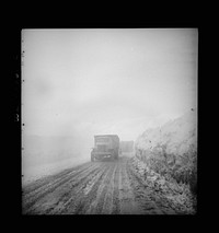 Somewhere in the Persian corridor. A United States Army truck convoy carrying supplies for Russia climbing into the clouds through a risky pass over the mountains. The road was cut out of the ice. Sourced from the Library of Congress.