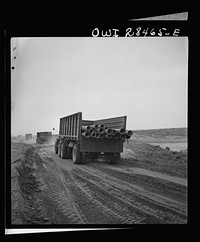Somewhere in the Persian corridor. A United States Army truck convoy carrying supplies for Russia moving along on a sandy desert road. Sourced from the Library of Congress.
