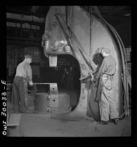 Pitcairn, Pennsylvania. Mrs. Katie Sablejack, forty-five, a Hungarian, employed as a smith's helper in the Pennsylvania Railroad yards, earning seventy-two cents per hour. She is operating a half-ton steam hammer. Mrs. Sablejack is a widow and mother of two children. Sourced from the Library of Congress.