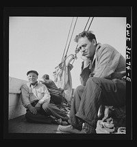 On board the fishing boat Alden out of Gloucester, Massachusetts. Fishermen sitting about the deck on the first morning. Sourced from the Library of Congress.