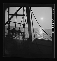 On board the fishing boat Alden, out of Gloucester, Massachusetts. Fishing schooner towing a dory off the New England coast. Sourced from the Library of Congress.