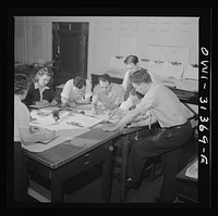 Washington, D.C. Preparing an advisory forecast at the U.S. Weather Bureau.  Joe F. Fulks supervising the preparation of weather analyses. Sourced from the Library of Congress.