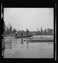 [Untitled photo, possibly related to: Spring pulpwood drive on the Brown Company timber holdings in Maine. Woodsmen in a "bateau" opening up on empty boom. These boats are used primarily to clean out logs which have been caught on snags or islands in the large streams and rivers]. Sourced from the Library of Congress.