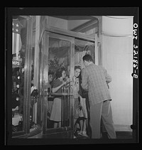 Washington, D.C. A shoe store clerk opening the door to customers on the last day on which war ration shoe coupon seventeen may be used. Sourced from the Library of Congress.