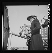 Gloucester, Massachusetts. Memorial services for a fisherman lost at sea. The fisherman's widow is tossing a bunch of flowers into the sea. Sourced from the Library of Congress.