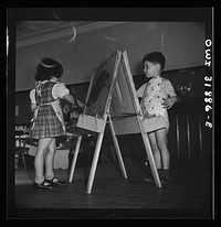 New Britain, Connecticut. A child care center, opened September 15, 1942, for thirty children, age two to five, of mothers engaged in war industry. The hours are 6:30 a.m. to 6 p.m. six days per week. Children painting and coloring. Sourced from the Library of Congress.