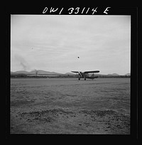 [Untitled photo, possibly related to: Bar Harbor, Maine. Civil Air Patrol base headquarters of coastal patrol no. 20. Low horsepower plane, used only for courier duty, being steadied in a strong wind by two ground crew men]. Sourced from the Library of Congress.