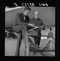 Bar Harbor, Maine. Civil Air Patrol base headquarters of coastal patrol no. 20. Chief engineering officer and radio expert checking reports in the hangar. Sourced from the Library of Congress.