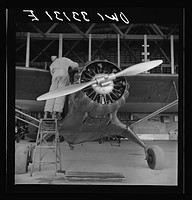 Bar Harbor, Maine. Civil Air Patrol base headquarters of coastal patrol no. 20. Ground crew mechanic working on a patrol plane in the hangar. Sourced from the Library of Congress.