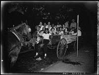 [Untitled photo, possibly related to: Washington, D.C. A group of Washington  war workers leaving the United Service Organization (USO) branch of the Young Mens' Christian Association (YWCA). Because of the gas rationing they are using horses and wagons for their hayride]. Sourced from the Library of Congress.