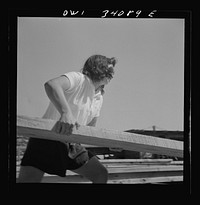 [Untitled photo, possibly related to: Turkey Pond, near Concord, New Hampshire. Women workers employed by a U.S. Department of Agriculture timber salvage sawmill. Ruth De Roche, pit woman, placing a trimmed board on the proper pile in the pit]. Sourced from the Library of Congress.