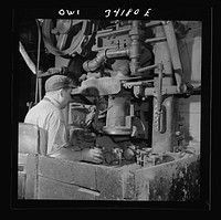 New Britain, Connecticut A core blowing machine. Sand is blown into the core box as it travels away from the machine on a conveyor. Sourced from the Library of Congress.