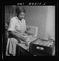 New Britain, Connecticut. A child care center opened September 15, 1942, for thirty children, ages two through five of mothers engaged in war industry. The hours are 6:30 a.m. to 6 p.m. six days per week. The dietician preparing milk for the lunch period. Sourced from the Library of Congress.