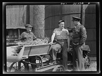 Rockville (vicinity), Maryland. Private Harvey Horton, visiting the N.C. Stiles dairy farm while on furlough from Fort Belvoir, Virginia, talking with Mr. Stiles and his nineteen-year-old son Robert. Sourced from the Library of Congress.