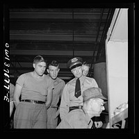 [Untitled photo, possibly related to: Pittsburgh, Pennsylvania. The regional safety instructor for the Greyhound bus company showing a group of new drivers one of the machines in the machine shop at the Greyhound garage]. Sourced from the Library of Congress.