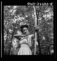 Bear Mountain, New York. Interracial activities at Camp Fern Rock, where children are aided by the Methodist Camp Service. Loretta Gyles of the Methodist Camp Service pulling a bow. Sourced from the Library of Congress.