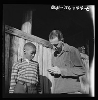 Southfields, New York. Interracial activities at Camp Nathan Hale, where children are aided by the Methodist Camp Service. Mr. Lewis Traver, the director, giving instruction to one of the campers. Sourced from the Library of Congress.