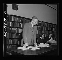 Washington, D.C. Principal Norman J. Nelson giving instuction to the faculty for issuing ration books, Woodrow Wilson High School. Sourced from the Library of Congress.