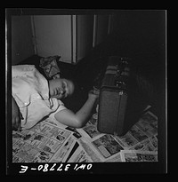 Louisville, Kentucky. A bus passenger sleeping on the floor at the Greyhound bus terminal because she had a nine hour stopover and all the benches were full. Sourced from the Library of Congress.